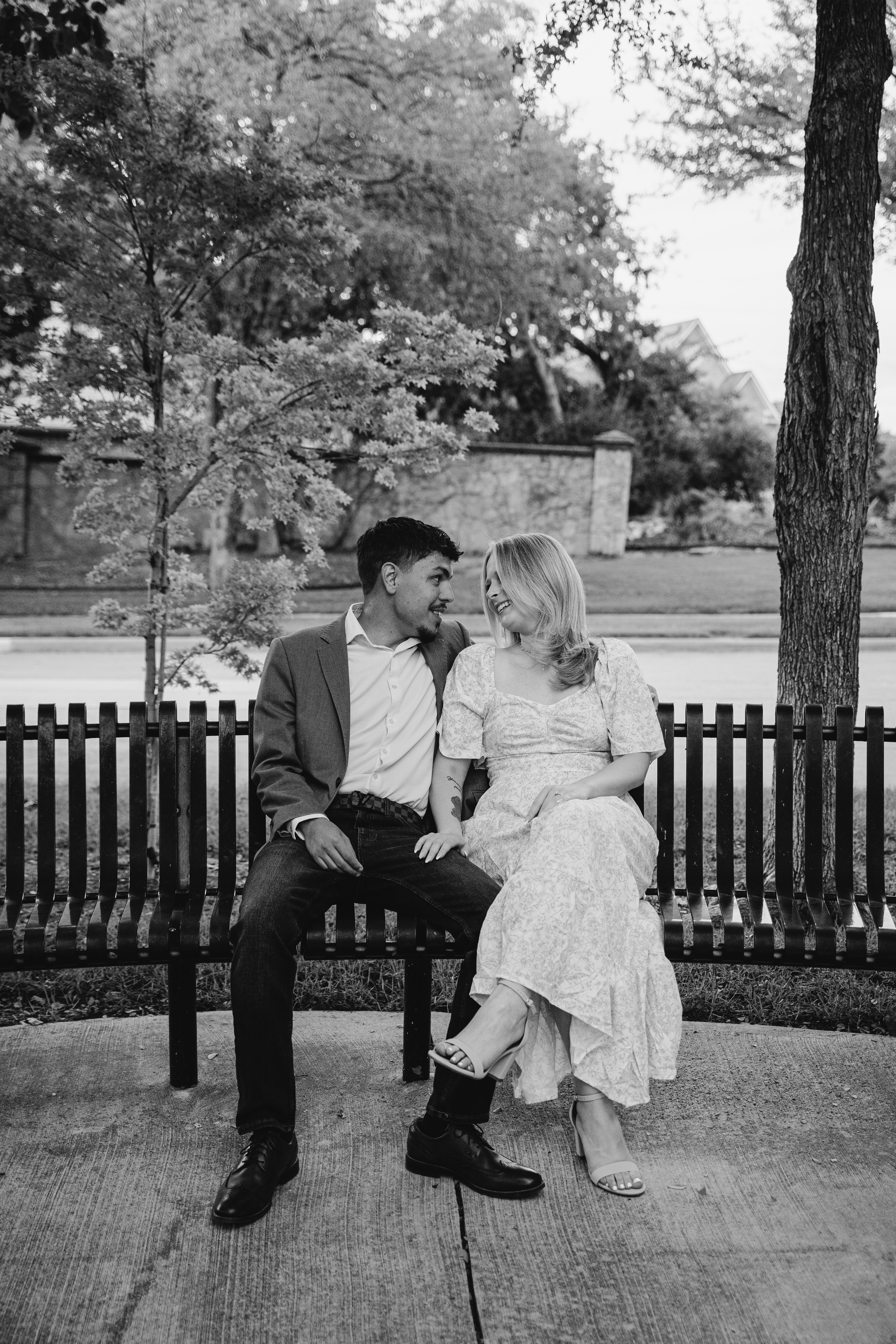 Eli and Shailyn sitting on a park bench in black and white